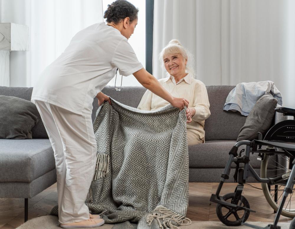 Eine Krankenschwester, die einen Patienten mit einer Decke zudeckt.